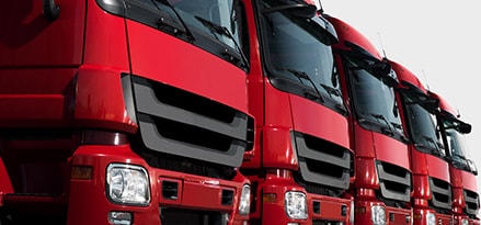 Four red semi-trucks in a row